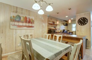 Enjoy meals with family and friends at the dining table for six, surrounded by a beautiful painting of trees.