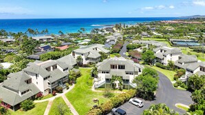 A coastal residential area with houses, a road, and a view of the ocean.