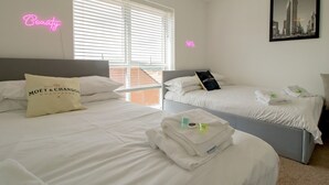 Ett hotellrum med två sängar, utsikt över staden och neonljus på väggarna.