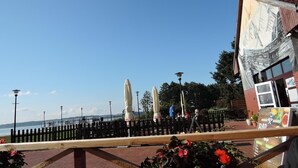 Un restaurant situé au bord de l’eau, avec une terrasse, des parasols et une vue sur le plan d’eau.
