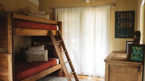 Una litera con escalera, un escritorio de madera y un letrero que dice 'Cabin sweet Cabin'.