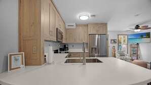 Eine moderne Küche mit Holzausstattung, Edelstahlgeräten und einer weißen Arbeitsplatte.