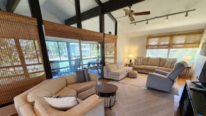 A spacious living area with a large sofa, a smaller sofa, a coffee table, and a television.