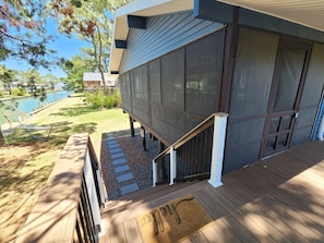 Ein modernes Haus mit einer Terrasse, einer Treppe und Seeblick.