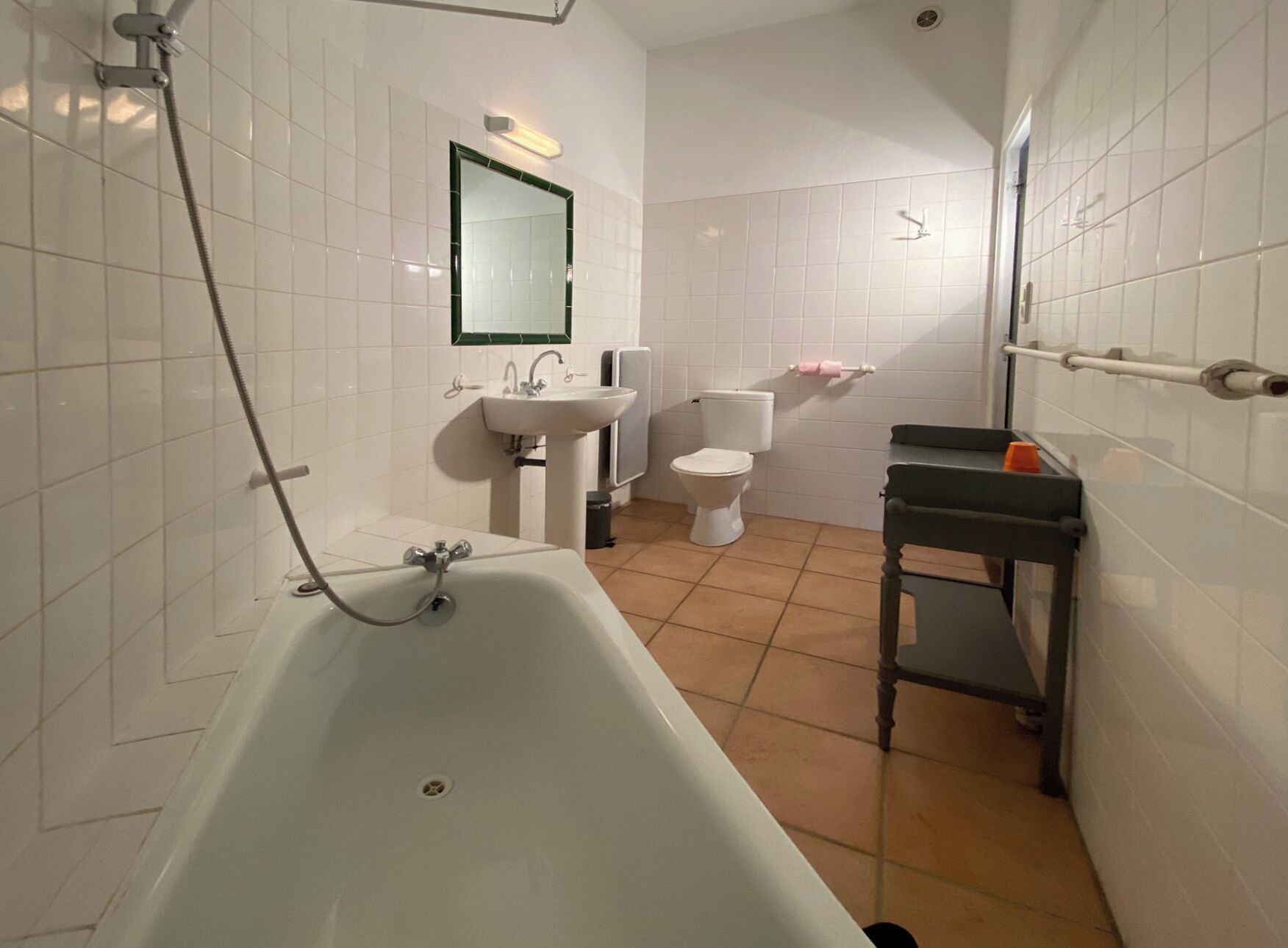 Un baño con bañera, lavamanos, inodoro y espejo.