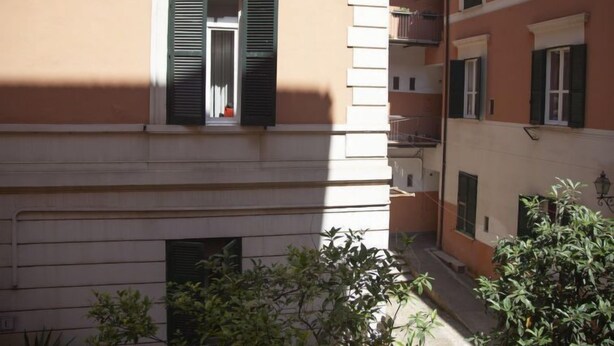 A multi-story building with balconies and a window with closed shutters. - Testaccio Piramide by Interhome (Rome: Historical City Center)