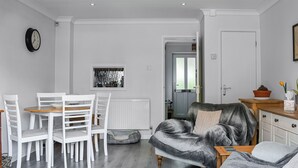 A modern living room with a dining area, a grey sofa, and a white radiator. - 2 bedroom accommodation in Wareham (Wareham)