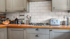 A kitchen with grey cabinets, a wooden countertop, a Kenwood toaster, and a bowl of fruit. - 2 bedroom accommodation in Wareham (Wareham)