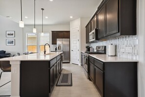 Enjoy cooking in this well-equipped kitchen with a central island, sink, and ample counter space.