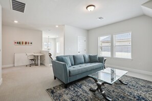 Relax in this inviting living room with a comfortable sofa, coffee table, and patterned rug.