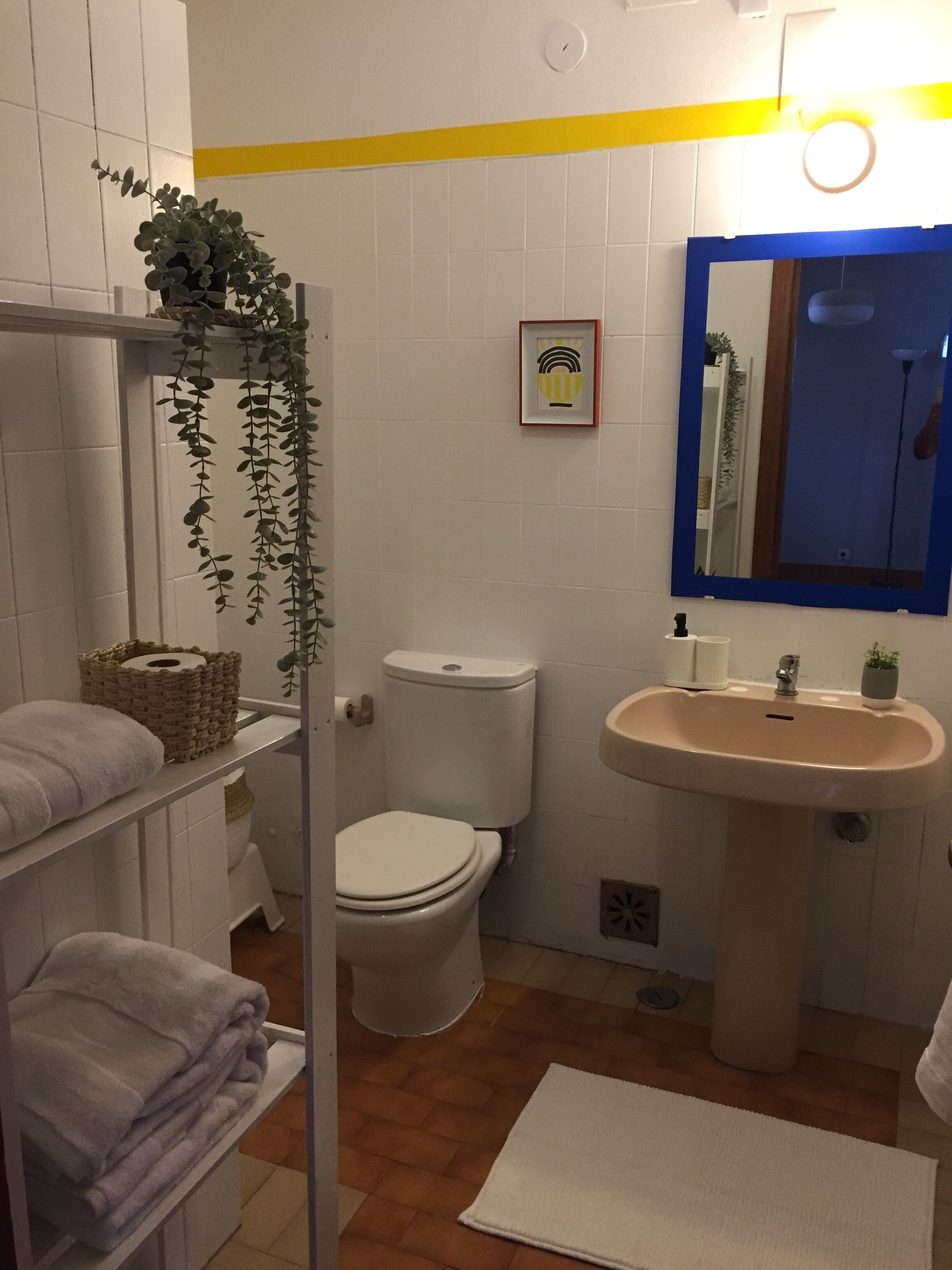A bathroom with a toilet, sink, and towel rack.