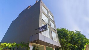 A modern hotel with a prominent 'HOTEL VIEW' sign, large windows, and a flat roof. - A Boutique Hotel View (New Delhi)