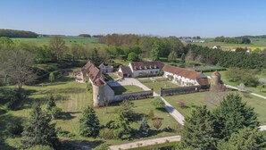 A castle-like structure with multiple buildings, a large courtyard, and surrounding greenery. - Magnifique Domaine de Caractère en Pleine Nature (GY LES NONAINS)