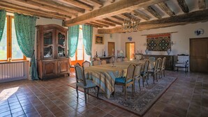 A dining room with a long wooden table, chairs, and a chandelier. - Magnifique Domaine de Caractère en Pleine Nature (GY LES NONAINS)