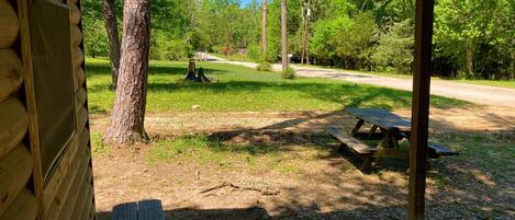 A wooden cabin with a picnic table and a concrete deck.