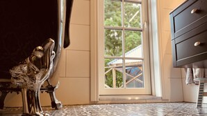 Una stanza con pavimento decorato, un armadietto in legno scuro e una finestra vista casa.