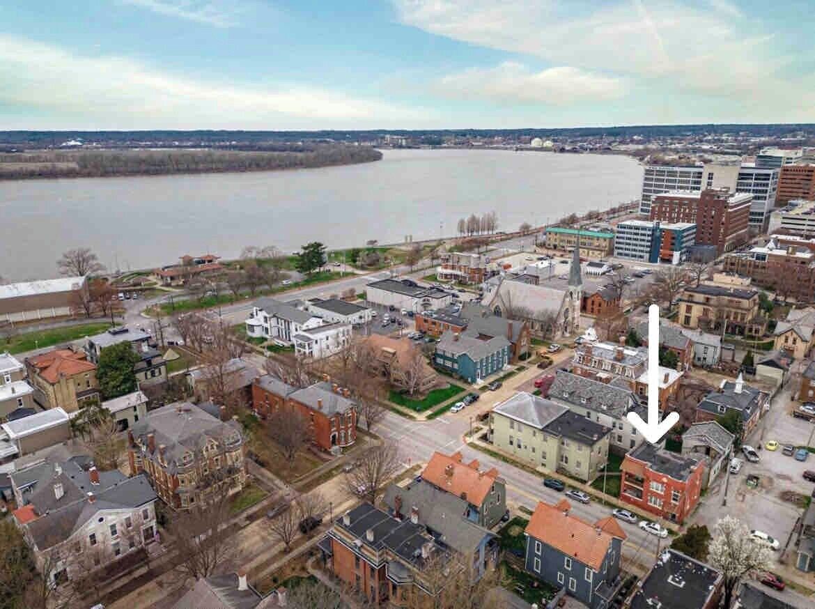 An aerial view of a town with a river, buildings, and a prominent church steeple.
