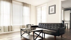 A modern living room with a leather sofa, a coffee table, and a framed picture on the wall.