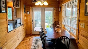 L’intérieur d’une cabane en bois comprend un coin repas, une cuisine et un escalier.
