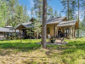 A rustic cabin with a wooden exterior, a porch, and a dining area with outdoor furniture.