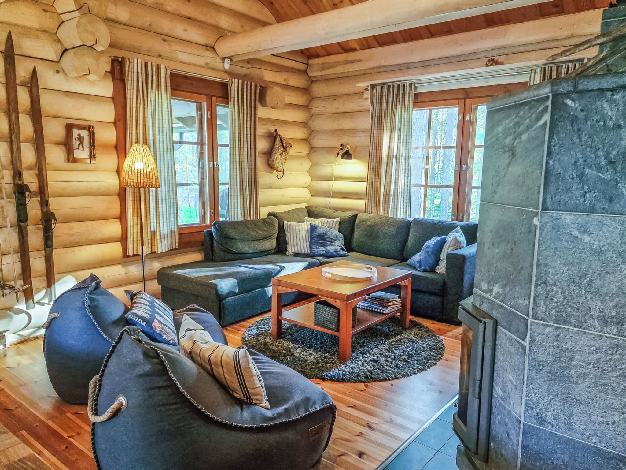 A log cabin interior with a fireplace, a sofa set, and a dining table.