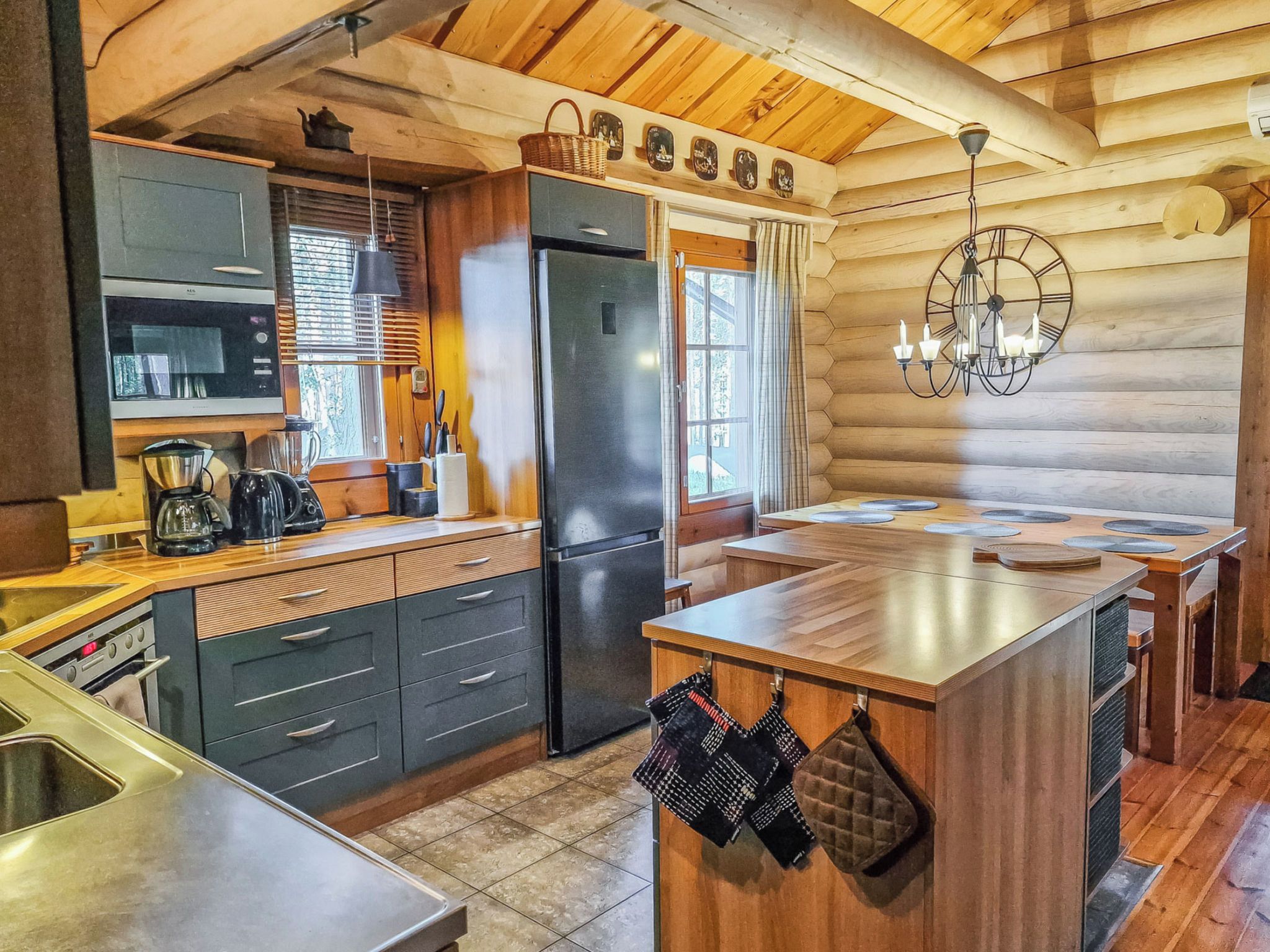 Une cuisine moderne avec des meubles en bois, un réfrigérateur en acier inoxydable et un îlot central doté d’un évier.