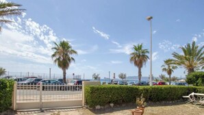 A parking area with a gated entrance, palm trees, and a clear sky. - Les Vagues by Interhome (Saint Cyr sur mer Les Lecques)