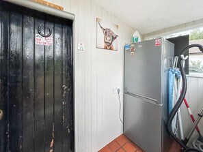 Keittiössä on jääkaappi, ovi, jossa on tupakointikieltoa osoittava kyltti, ja seinään kiinnitetty lämmitin.
