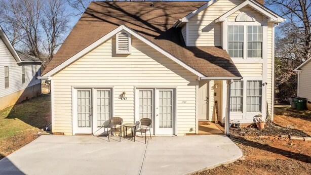 A two-story house with a front porch, two garage doors, and a chimney. - EverStay Duplex “Suite B” Close to Everything  (charlotte)