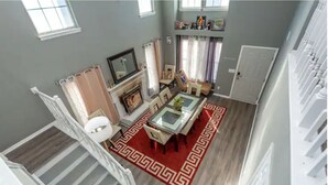 A spacious living room with a fireplace, a dining area with a patterned rug, and a staircase leading to another level. - EverStay Duplex “Suite B” Close to Everything  (charlotte)