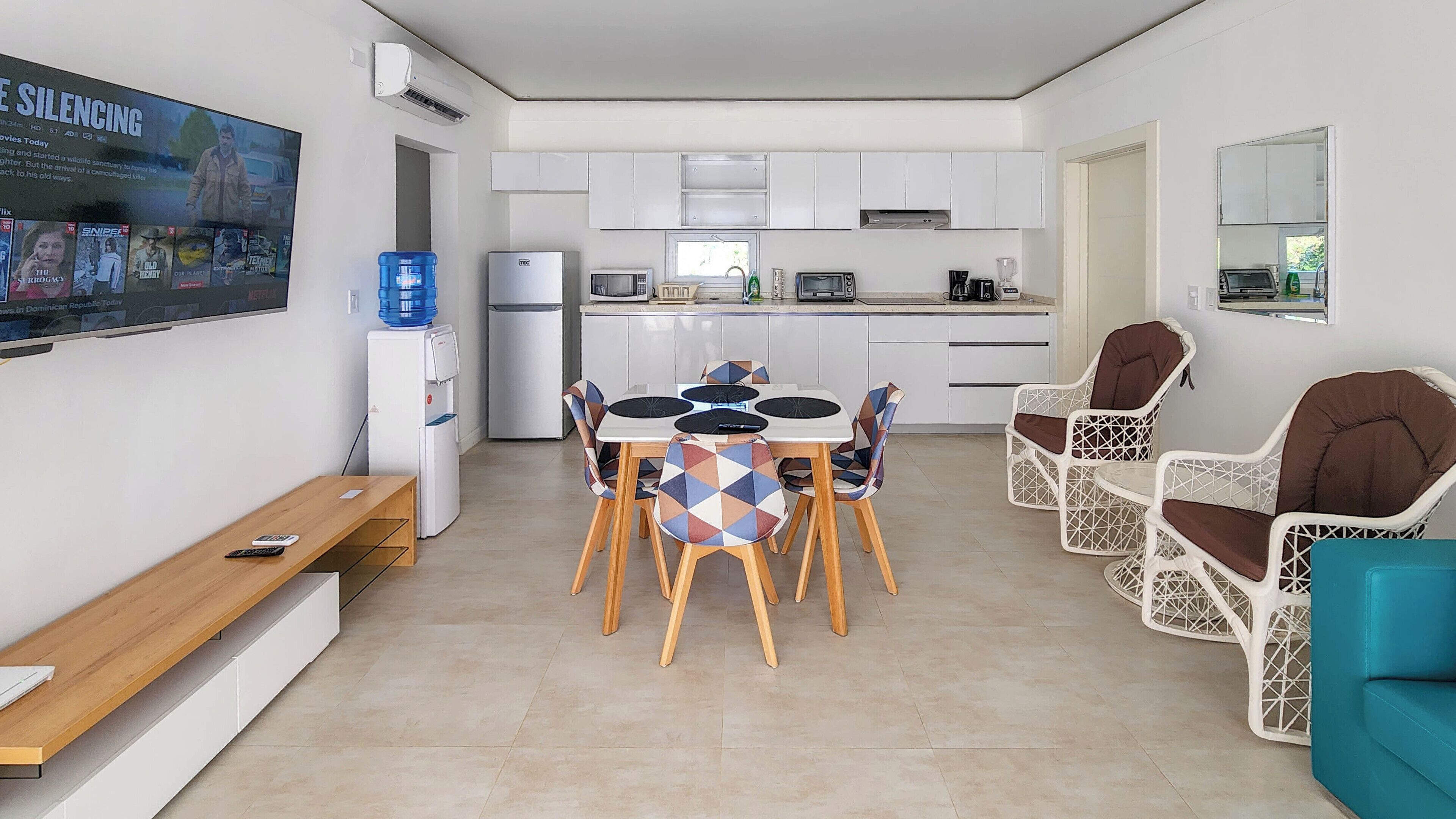 A modern kitchen with white cabinets, a built-in microwave, and a water dispenser.