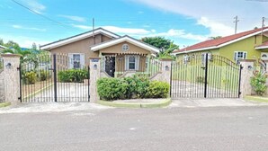 A gated residential area with two houses, each with a distinct architectural style and a gated entrance.