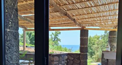 typical Sicilian stone house on the sea surrounded by greenery