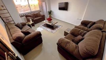 Habitación triple urbana | Área de sala de estar | Televisión LCD, piso con calefacción y oficina