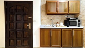 A kitchen with wooden cabinets, a microwave, and a sink.