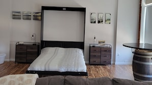 Ein Schlafzimmer mit einem großen Bett, zwei Nachttischen, einer Kommode und einem runden Tisch.