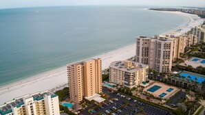 A high-rise hotel with a pool, beach view, and parking lot. - SEA WINDS 1201  
Beach Front Getaway with spectacular views of the Gulf! (Marco Island)