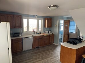 Kitchen features a dishwasher, toaster, and sink with a faucet, plus a window above the sink.