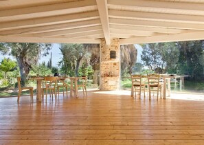 Enjoy al fresco dining on the deck, surrounded by trees and a clear sky.