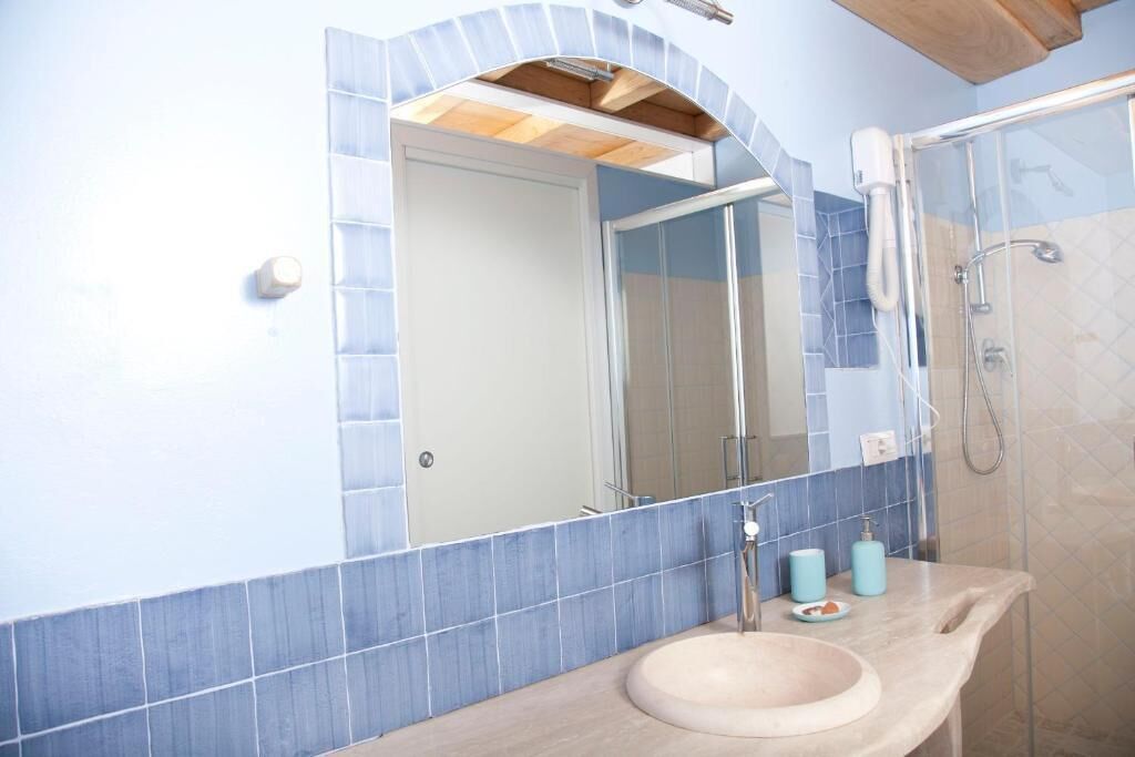 Un baño con lavamanos, espejo y ducha.
