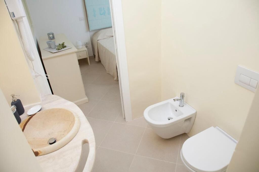 Un baño con tocador de madera, un bidé y un inodoro.