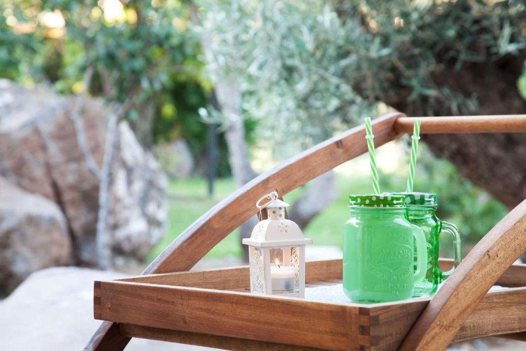A wooden tray with a white lantern and two green mason jars.
