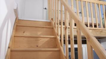 Una scala in legno con corrimano che conduce a un piano superiore.