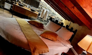 Un lit avec une tête de lit en bois, une table de chevet et une lampe.