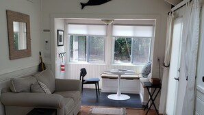 A modern living room with a sofa, a coffee table, and a dining area with a table and chairs.