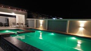 A swimming pool with a tiled deck and a small seating area with chairs. - 2,3 Ensuite Bedrooms Luxury Staycation and Vacation apartments (Kasoa)