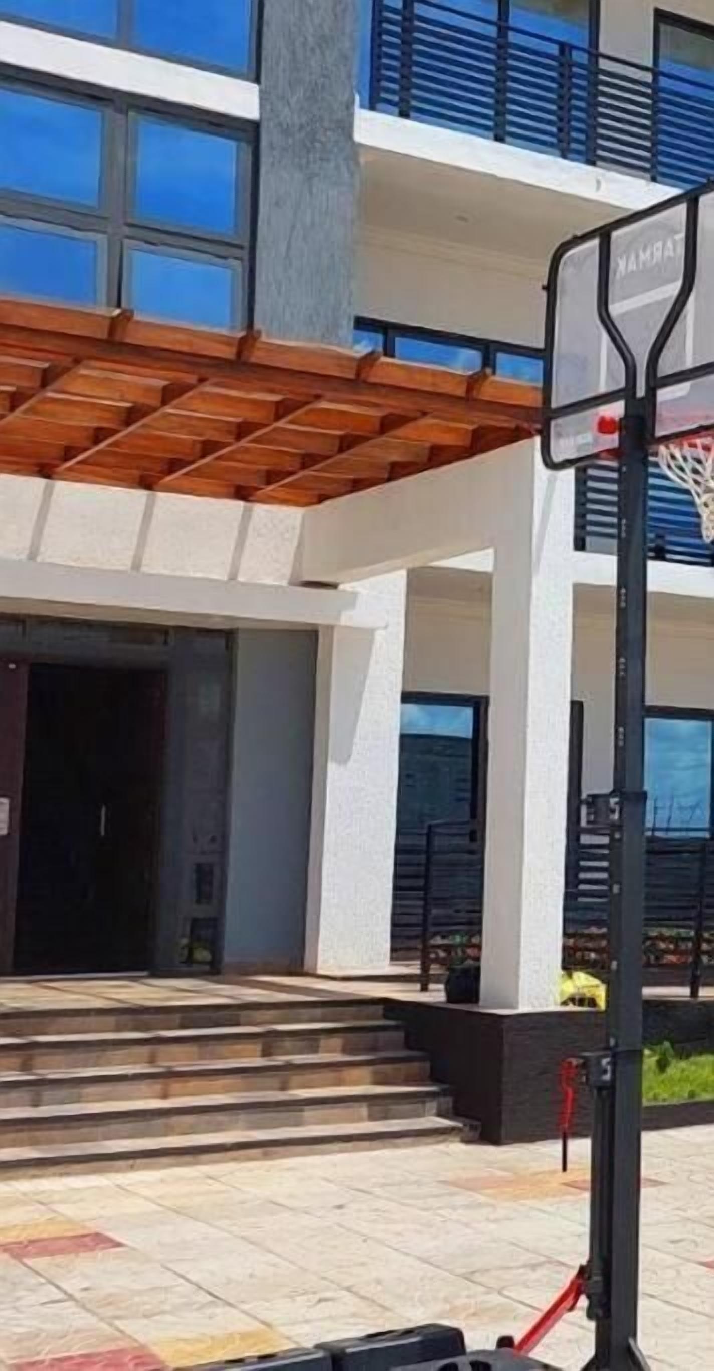 Un edificio moderno con un canestro da basket di fronte.