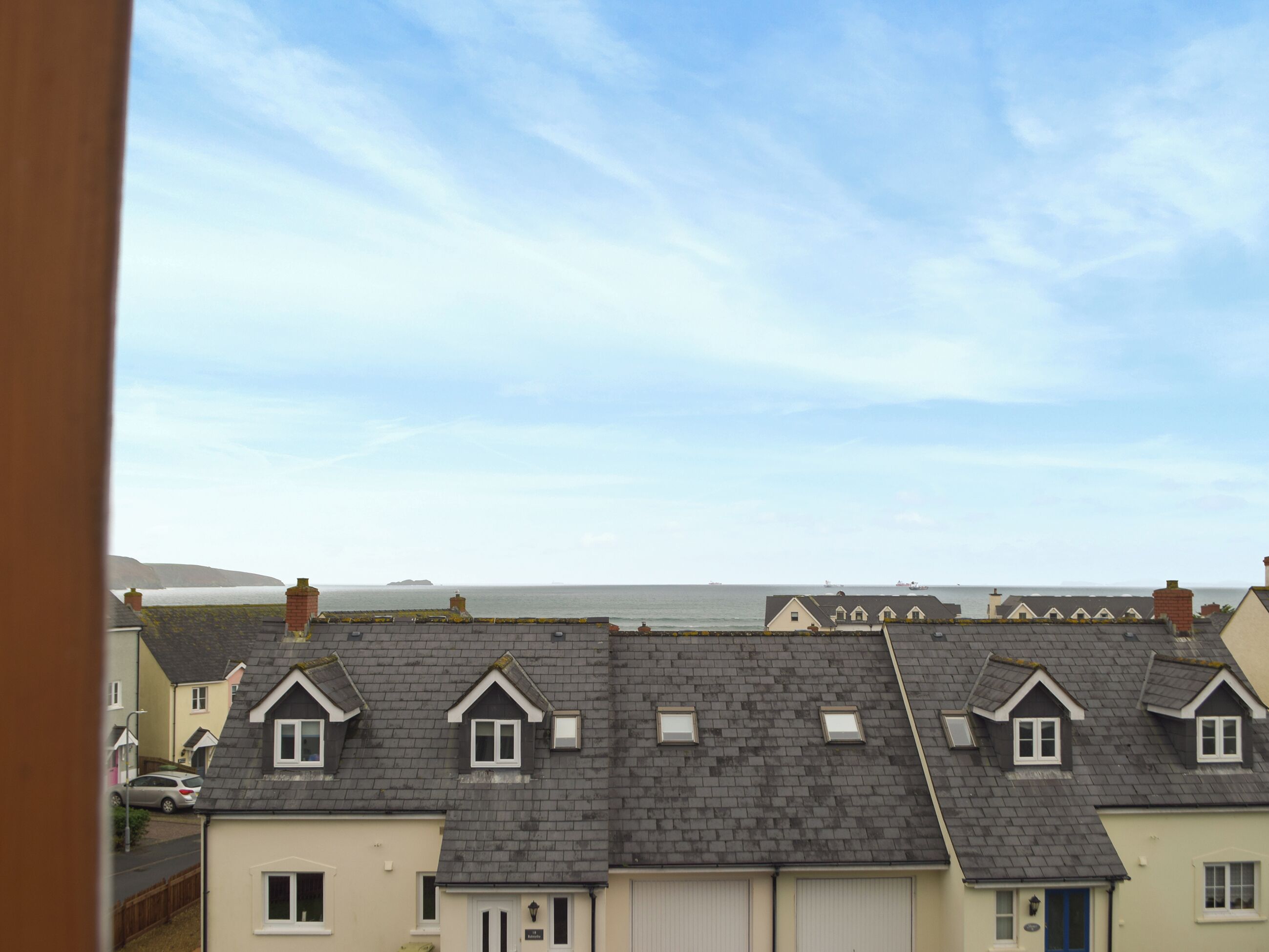A row of terraced houses with a view of the sea.