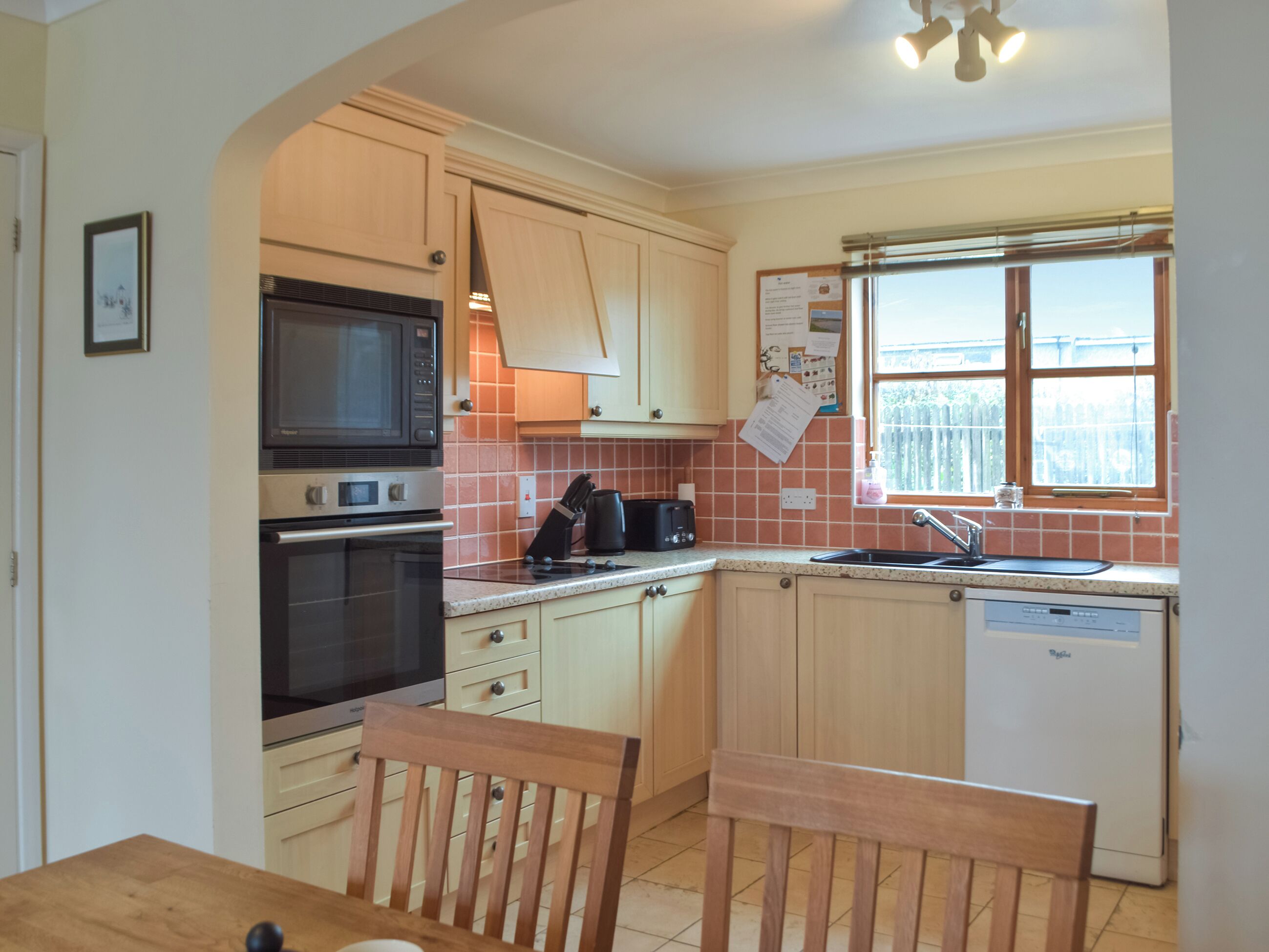 A kitchen with wooden cabinets, a microwave, a toaster, and a dishwasher.