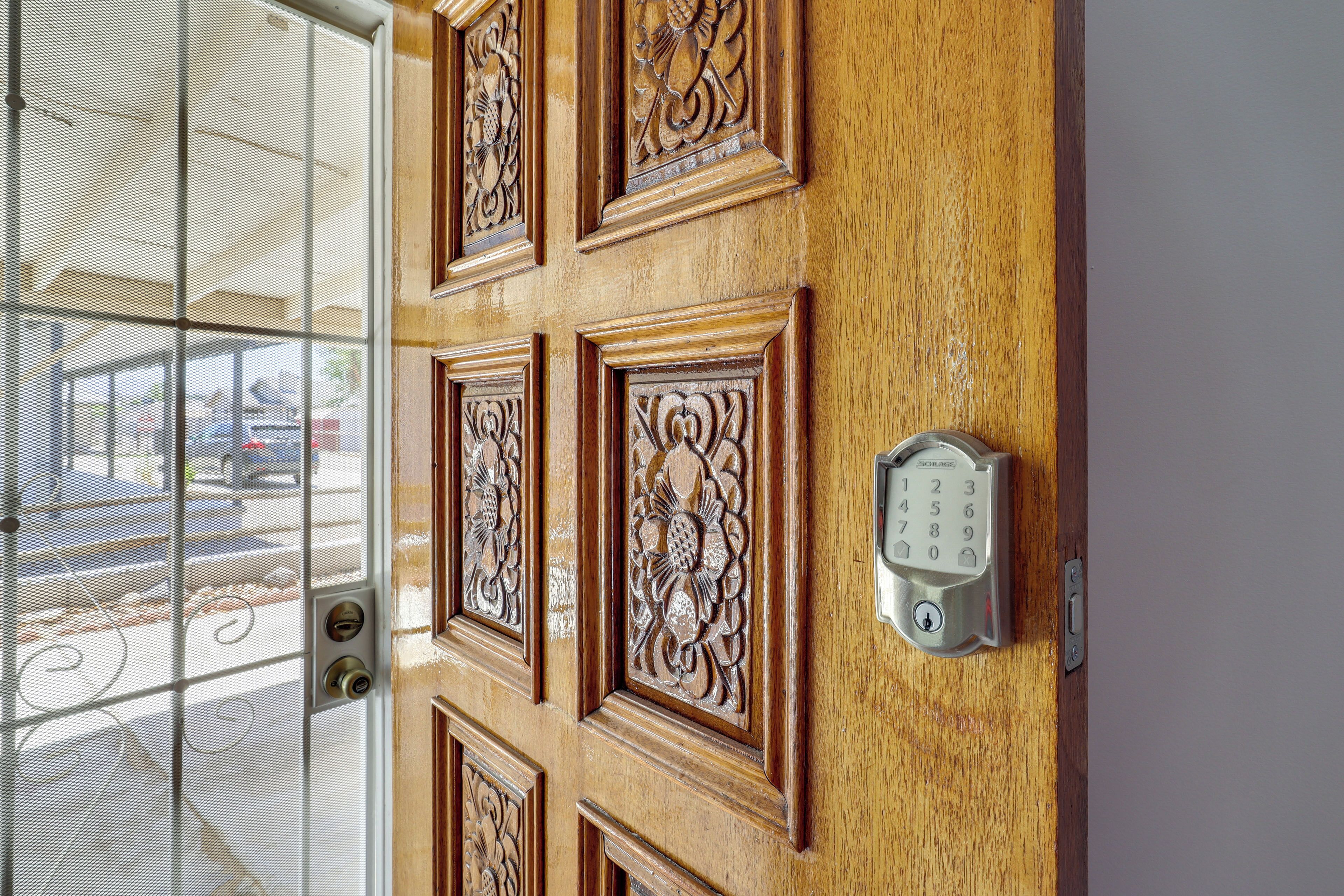 Uma porta de madeira com esculturas detalhadas e fechadura eletrônica.